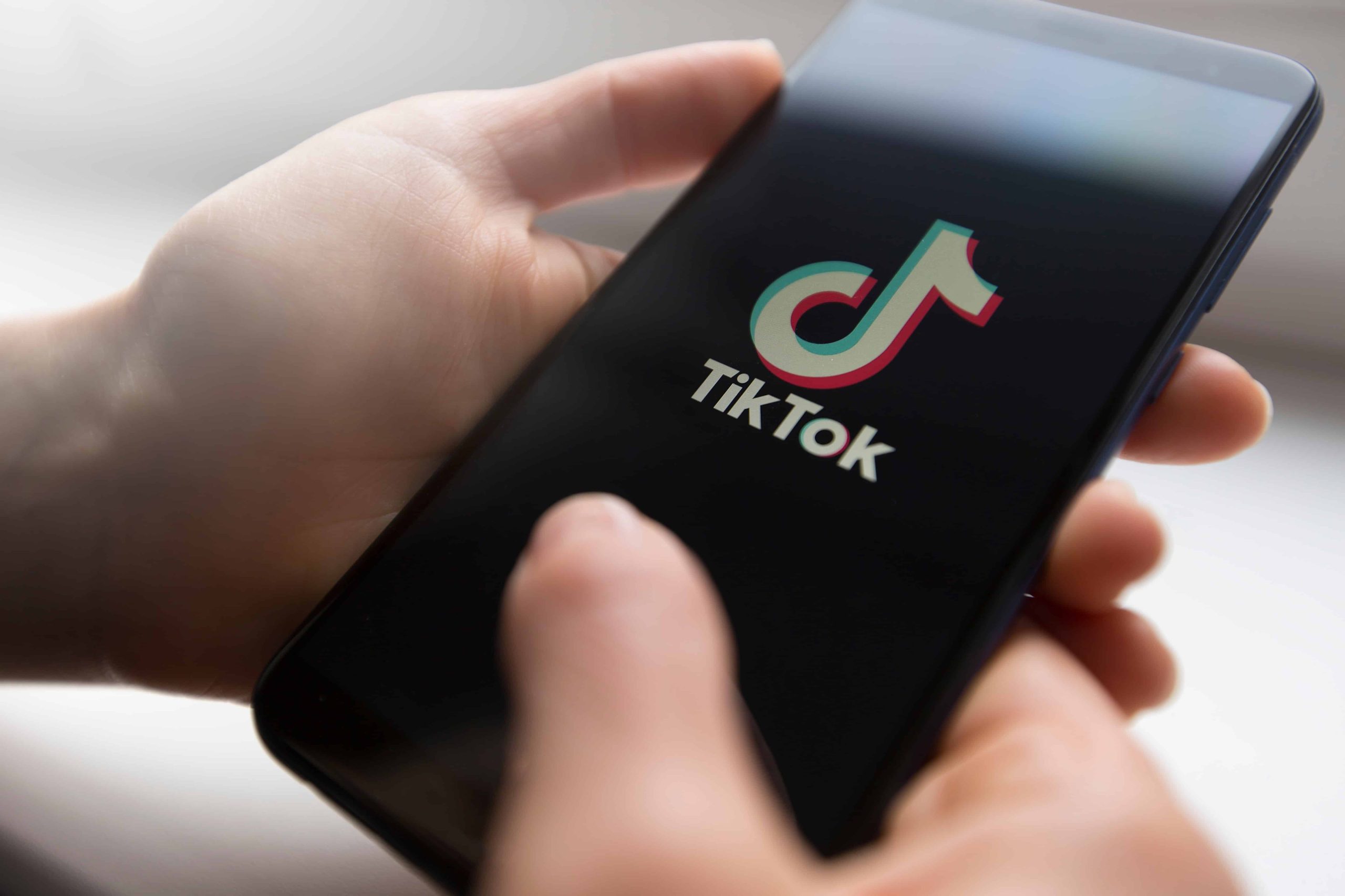 Personne sur son téléphone cellulaire qui ouvre l'application TIk Tok